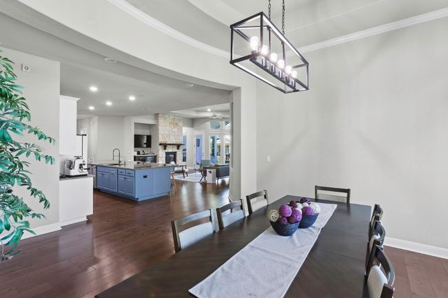 Dining room with dark wood-type flooring, baseboards, ceiling fan, recessed lighting, and ornamental molding | Image 11