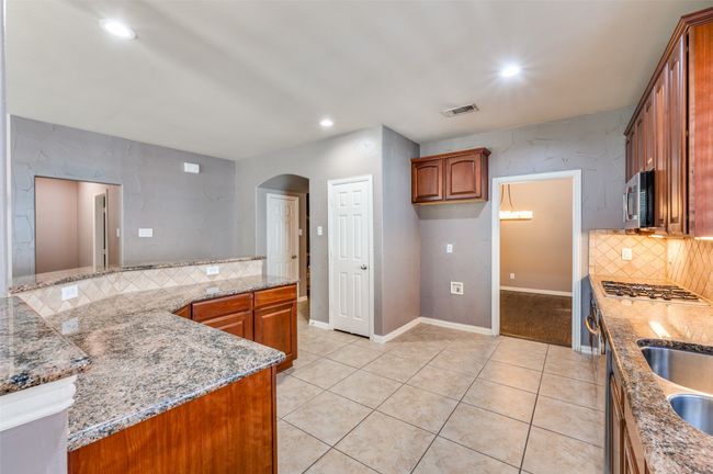 Kitchen featuring tasteful backsplash, granite counters, undermount and recessed lighting | Image 7