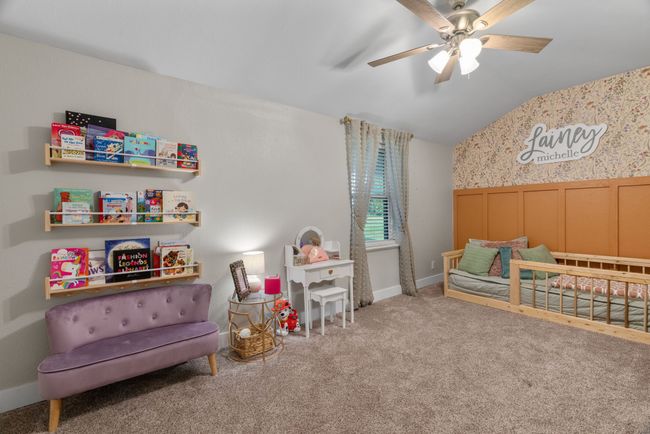 Recreation room with lofted ceiling, carpet, ceiling fan, a wainscoted wall, and wallpapered walls | Image 34