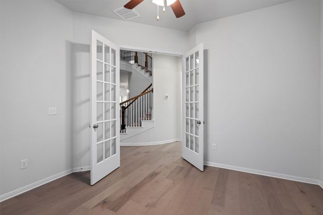 Empty room featuring visible vents, wood finished floors, ceiling fan, and french doors | Image 5