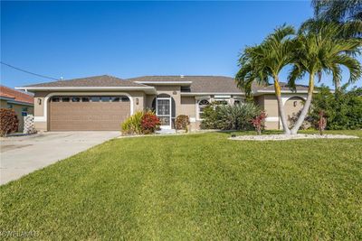 View of front facade with a front yard and a garage | Image 1