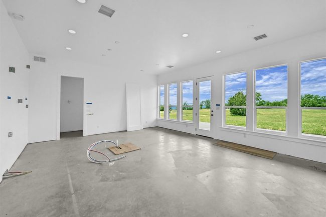 Flex-Space within climate-controlled space inside shop. This area is partially finished, giving you the opportunity to complete it to your liking. The main level is laid out for a lounge/game room with a pre-wired & pre-plumbed kitchen area, a bonus room with a closet, & a full bath with washer/dryer hookups. HVAC, water, plumbing are in place. Materials for finishing, including flooring, stainless induction cooktop, wall oven, and an electric fireplace, are included and ready for installation. | Image 38