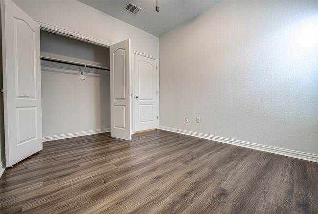Unfurnished bedroom with dark wood-type flooring and a closet | Image 12