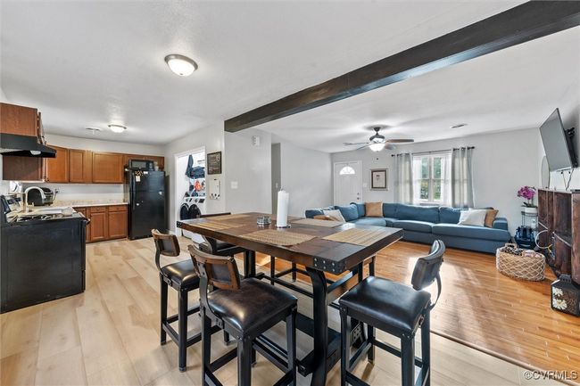 Dining room with light wood-type flooring, washer / dryer, a ceiling fan, and beamed ceiling | Image 14