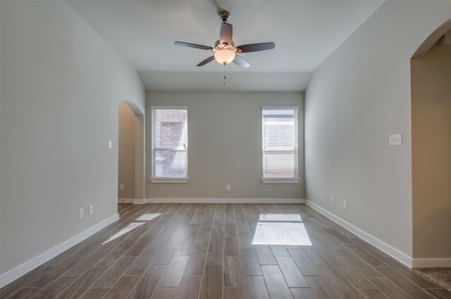 Spare room with arched walkways, plenty of natural light, and a ceiling fan | Image 4