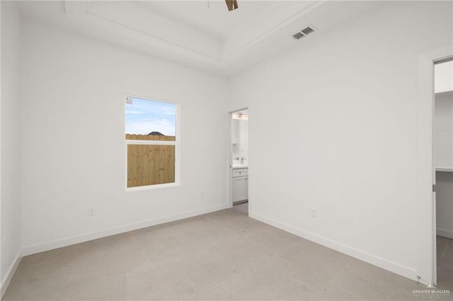 Unfurnished bedroom with a spacious closet, ensuite bathroom, a ceiling fan, and a closet | Image 13