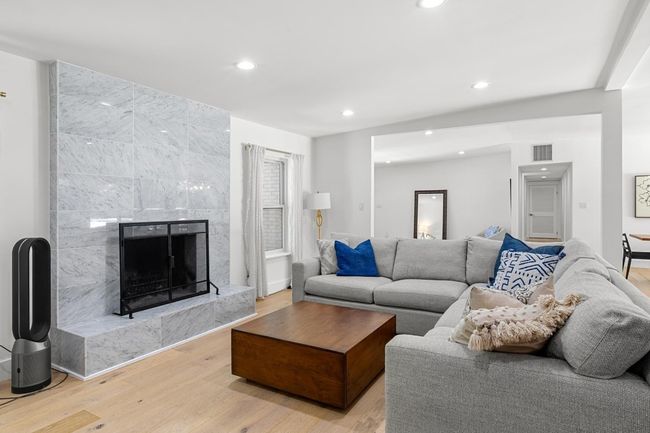 Living room featuring a high end fireplace, light wood-style flooring, visible vents, recessed lighting, and baseboards | Image 15