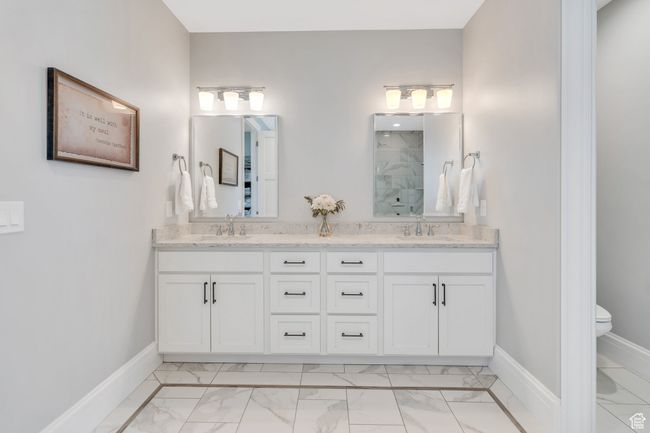 Full bathroom featuring marble finish flooring, a marble finish shower, and double vanity | Image 32
