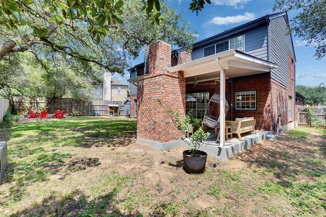 Rear view of property featuring brick siding, a patio area, a fenced backyard, and a chimney | Image 31