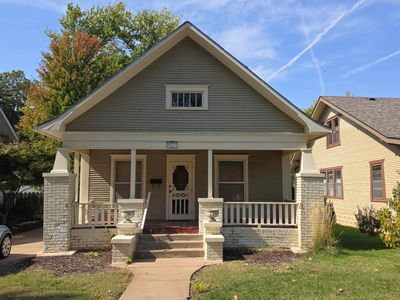 Bungalow-style house featuring a porch and a front yard | Image 1