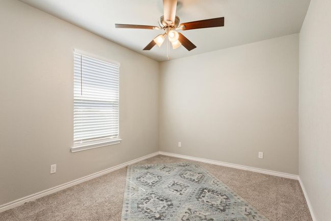 Carpeted empty room with ceiling fan and baseboards | Image 25