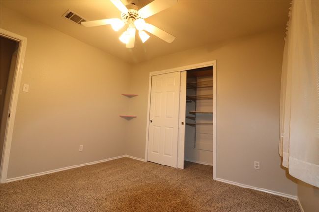 Unfurnished bedroom featuring carpet floors, a closet, and ceiling fan | Image 12
