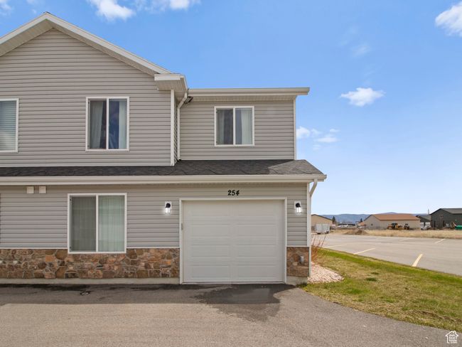 View of side of home with roof with shingles, an attached garage, and stone siding | Image 9