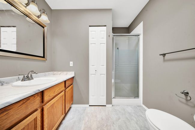 Full bathroom with toilet, a stall shower, baseboards, and vanity | Image 15