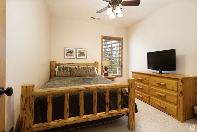 Bedroom with ceiling fan, visible vents, and light colored carpet | Image 39
