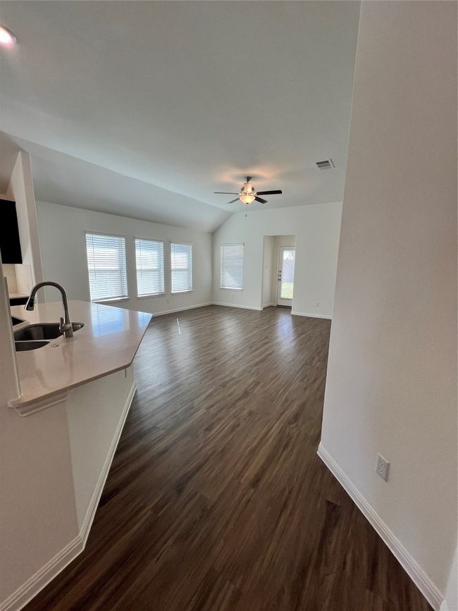 Unfurnished living room with lofted ceiling, dark wood-type flooring, and ceiling fan | Image 17