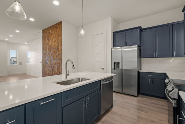Kitchen featuring recessed lighting, backsplash, a sink, light wood-style floors, and appliances with stainless steel finishes | Image 21