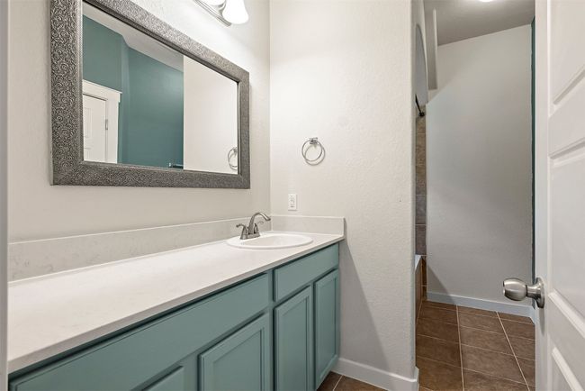 The ensuite bathroom features a single vanity and a shower/tub combo, creating a simple yet functional space for your daily routine with a relaxing vibe | Image 21