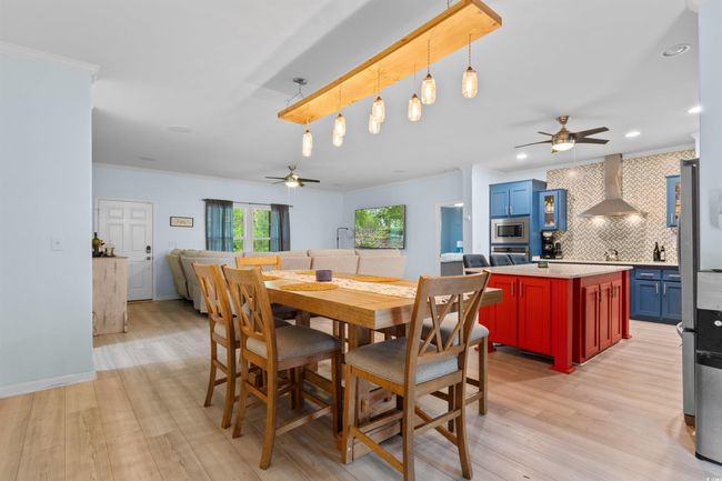 Dining area featuring ceiling fan, light wood-type flooring, crown molding, and recessed lighting | Image 7