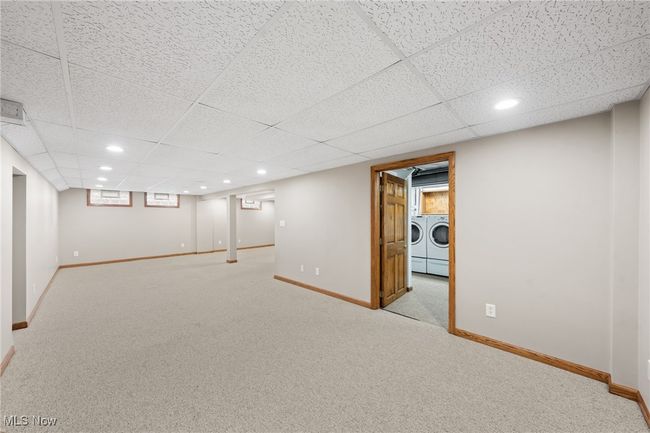 Basement featuring washer and clothes dryer, light carpet, and a paneled ceiling | Image 25