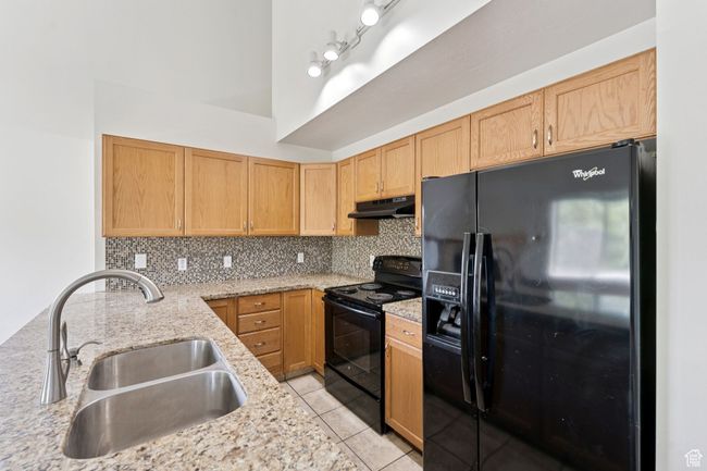 Kitchen with tasteful backsplash and granite countertops. | Image 7