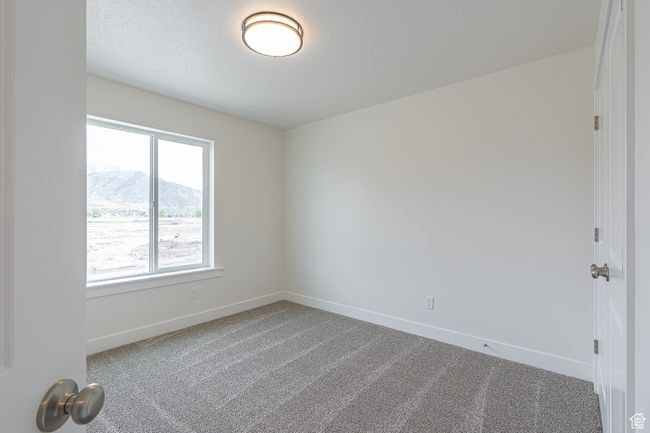 Carpeted empty room featuring baseboards and a mountain view | Image 11