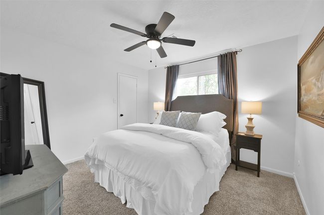 This Secondary Bedroom overlooks the Back Yard, has a ceiling fan with light and a generous walk-in closet. | Image 19