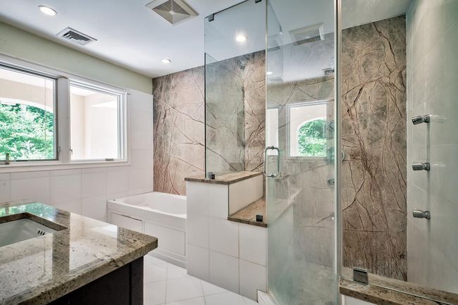 Bathroom with a healthy amount of sunlight, a marble finish shower, visible vents, and tile walls | Image 13