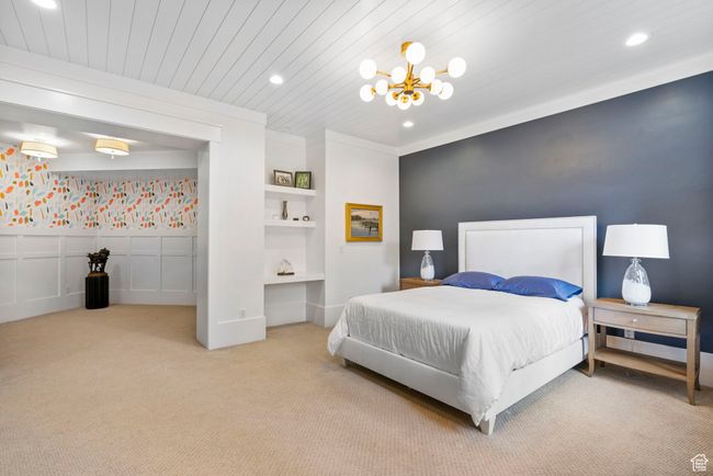 Carpeted bedroom featuring a wainscoted wall, recessed lighting, and a chandelier | Image 76