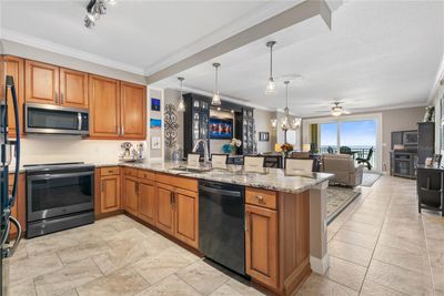 Beautifully remodeled Kitchen with lowered Granite countertops, newer appliances, enhanced modern lighting, wood cabinetry with many pull-outs, pantry and undermount lighting! | Image 3