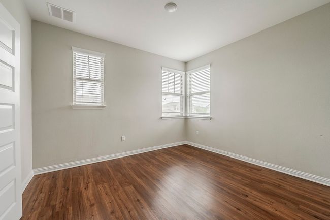 Spare room featuring a healthy amount of sunlight, baseboards, dark wood-style floors, and visible vents | Image 27