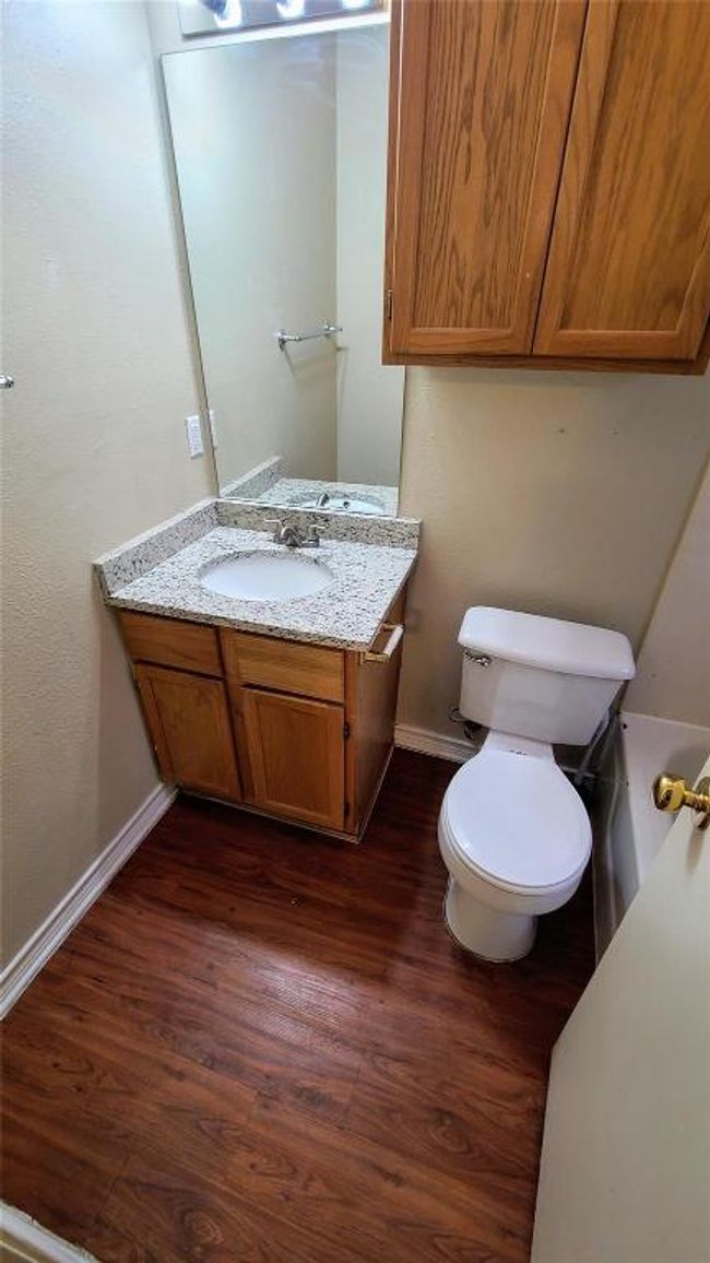 Bathroom with wood finished floors, vanity, baseboards, and toilet | Image 4