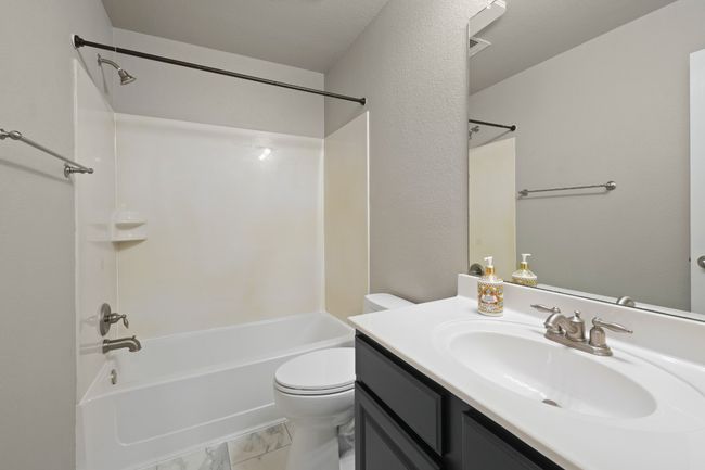Bathroom with vanity, tub / shower combination, toilet, and marble finish floors | Image 26