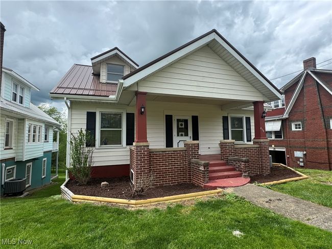 Bungalow-style home with central AC, a porch, a front lawn, and metal roof | Image 29