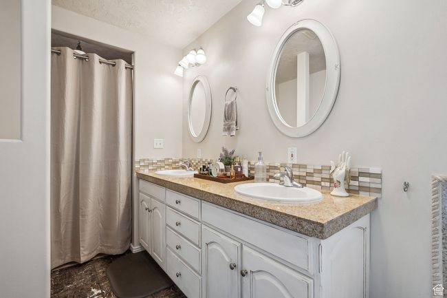 Bathroom with decorative backsplash, a sink, and double vanity | Image 23