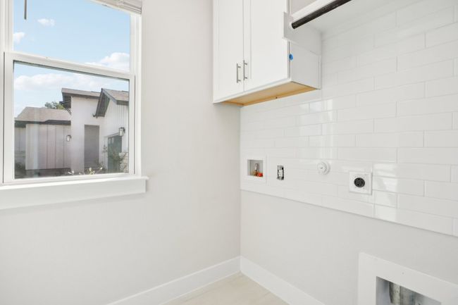 Laundry area with washer hookup, baseboards, cabinet space, and electric dryer hookup | Image 26