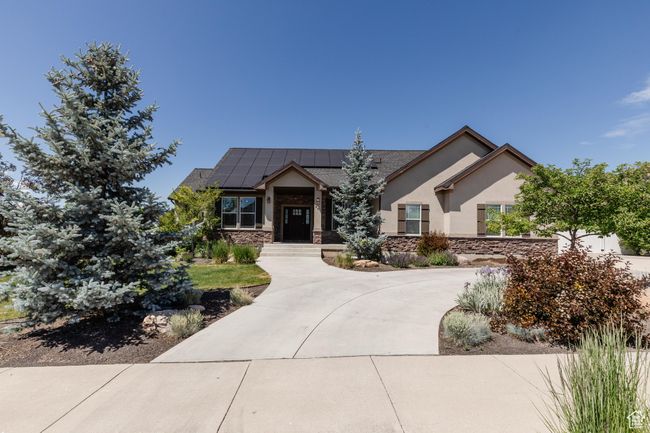 View of front of home featuring roof mounted solar panels, stone siding, and stucco siding | Image 52
