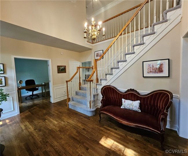 Stairway with wood finished floors, 2-story decorative chandelier, wainscoting, and crown molding | Image 10