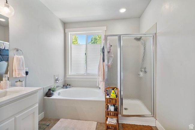 Full bathroom featuring a shower stall, a garden tub, vanity, and tile patterned flooring | Image 21