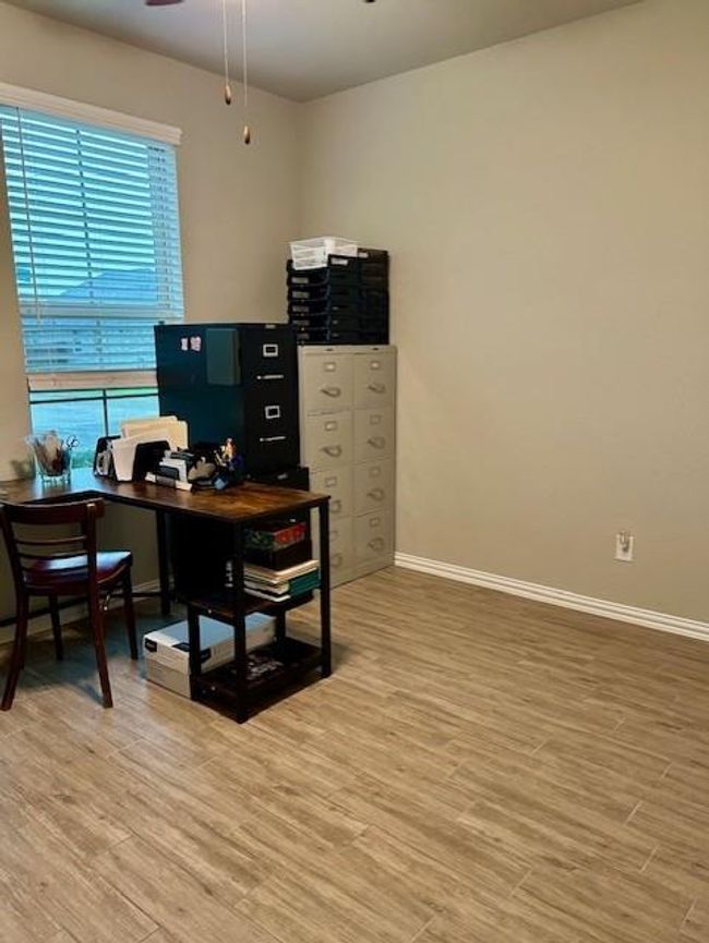 This versatile third bedroom is currently set up as a functional office. | Image 22