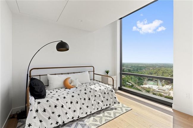 Bedroom with a wall of windows, baseboards, and wood finished floors | Image 19