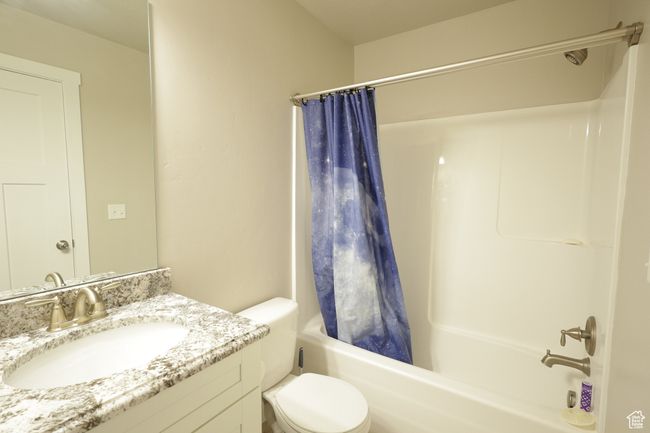 Full bathroom featuring shower / bathtub combination with curtain and vanity | Image 9