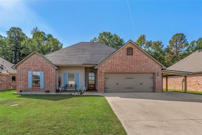 View of front of house featuring a front yard, a garage, and a carport | Image 1