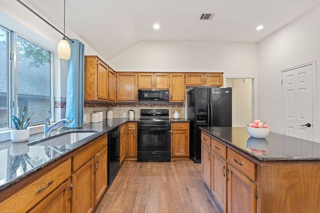 Featuring granite countertops, tile backsplash, and pantry storage. | Image 14