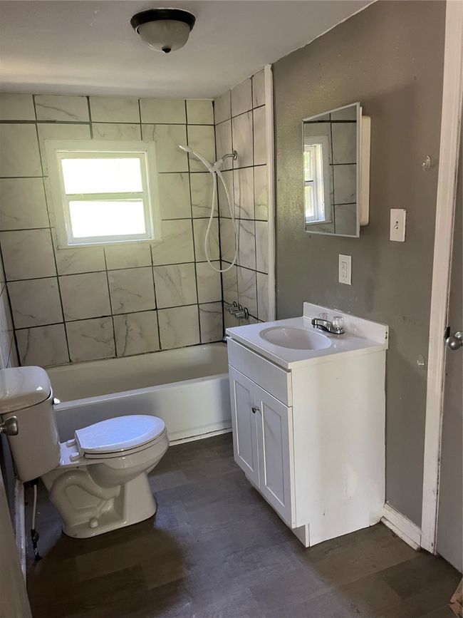Full bath featuring toilet, vanity, a healthy amount of sunlight, and washtub / shower combination | Image 14
