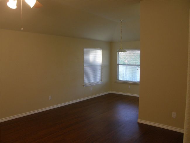 Empty room with dark wood finished floors, ceiling fan, and lofted ceiling | Image 4