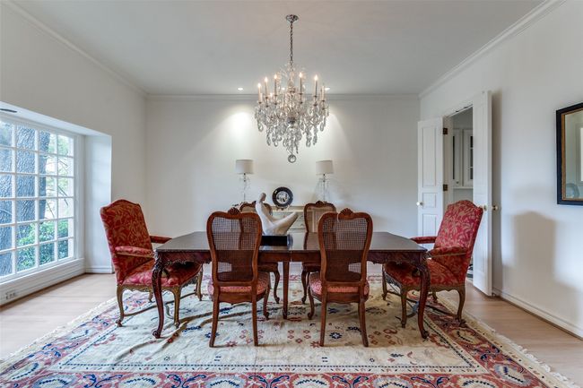 Dining area with a chandelier, wood finished floors, crown molding, and baseboards | Image 7