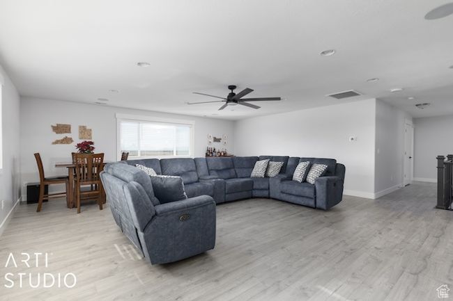 Living area featuring light wood finished floors, visible vents, baseboards, and a ceiling fan | Image 39