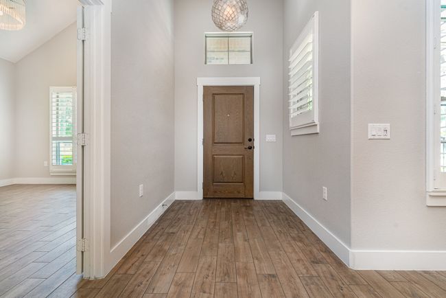 Entryway featuring wood finished floors, baseboards, and vaulted ceiling | Image 7