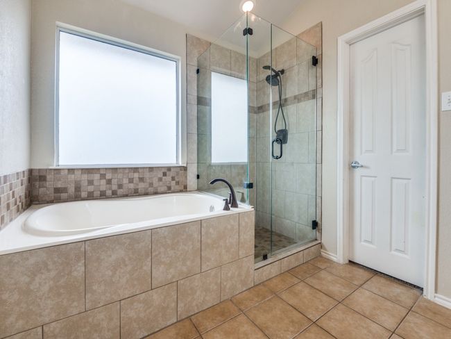Full bath with tile patterned floors, a stall shower, and a garden tub | Image 21